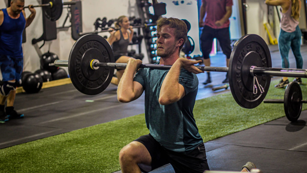 man doing a weighted front squat with a barbell